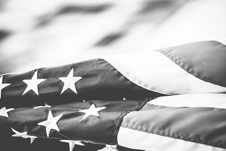 Foto in schwarz weiß der wehenden Fahne der USA, Foto: Todd Trapani , unsplash.com